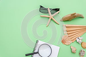 Travel vacation background concept with seashells and photo frames on green table. Top view with copy space. Flat lay