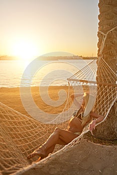 Travel and vacation concept - Woman relaxing on hammock on the beach