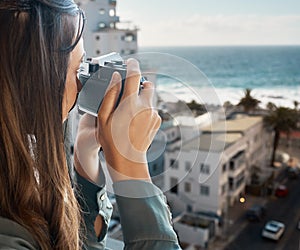 Travel, view and woman with camera at hotel taking pictures of the city, buildings or ocean on vacation. Photographer