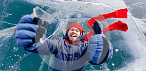 Travel winter Lake Baikal, smile man tourist in red cap lie on ice