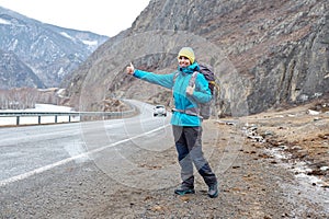 Travel woman hitchhiking. Beautiful young female hitchhiker by t