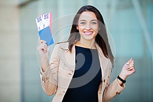 Travel. Woman holding two air ticket in abroad passport near airport