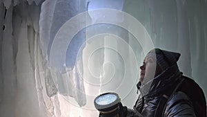 Travel woman on ice cave of Lake Baikal. Pov view selfie. Girl backpacker is walking of ice grot. Traveler looks at