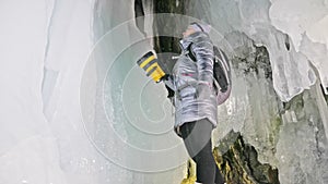 Travel woman on ice cave of Lake Baikal. Trip to winter island. Girl backpacker is walking of ice grot. Traveler looks