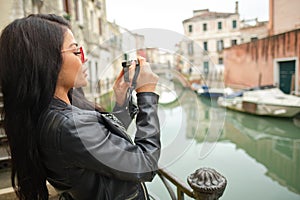 Travel woman photographer in Venice taking picture outside smiling