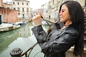 Travel woman photographer in Venice taking picture outside smiling