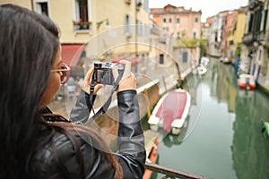 Travel woman photographer in Venice taking picture outside smiling