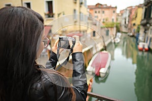 Travel woman photographer in Venice taking picture outside smiling