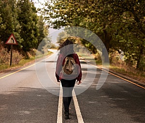 Travel, woman and walking with backpack on road in the countryside for hiking or journey in Ukraine. Back, girl or