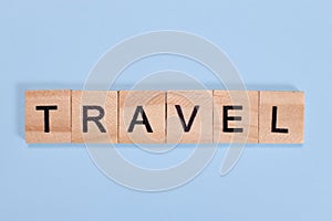 Travel word from wooden letters on blue background