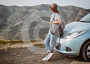 Travel - young beautiful hipster woman in hat travel by car, rent a car in vacations