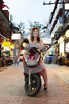 Travel while youre young. Portrait of a young woman using a map while travelling on a scooter in a foreign city.