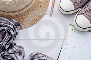 Traveler accessories and calendar on white wooden background. Vi