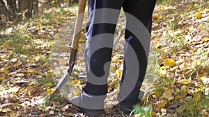 Traveler adventurer goes with a shovel in search of treasure. a man with a metal detector is looking for a treasure