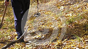 Traveler adventurer goes with a shovel in search of treasure. a man with a metal detector is looking for a treasure