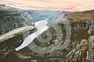 Traveler alone on the edge of Trolltunga cliff travel in Norway
