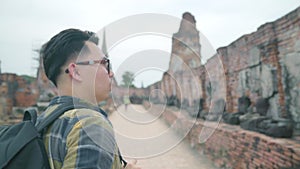 Traveler Asian man spending holiday trip at Ayutthaya, Thailand, backpacker male enjoy his journey at amazing landmark.