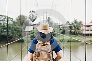 Traveler asian woman with backpack at foot bridge across river i