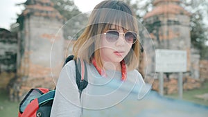 Traveler Asian woman direction and looking on location map while spending holiday trip at Ayutthaya, Thailand, backpacker female