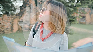 Traveler Asian woman direction and looking on location map while spending holiday trip at Ayutthaya, Thailand, backpacker female