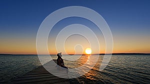 Traveler asian woman with her summer vacations on a twilight by the sea her sitting on bridge lonely dramatic lifestyle. Aegean