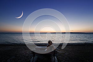 Traveler asian woman with her summer vacations on twilight by the sea her sitting on the shore looking at the moon lonely. Aegean