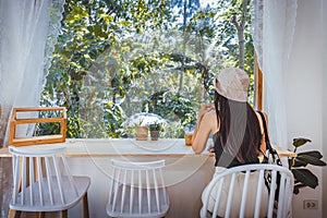 Traveler asian woman with Ice coffee plastic cup relax in cafe at Thailand