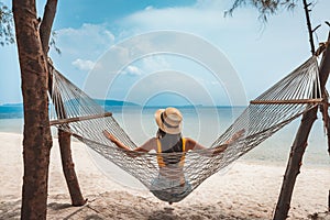 Traveler asian woman relax and travel in hammock on summer beach at Koh Rap Samui in Surat Thani Thailand