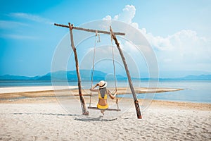 Traveler asian woman relax and travel in swing on summer beach at Koh Rap Samui in Surat Thani Thailand