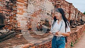 Traveler Asian woman spending holiday trip at Ayutthaya, Thailand, Japanese backpacker female enjoy her journey at amazing