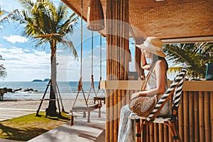 Traveler asian woman travel and relax on swing in beach cafe at Koh chang summer Thailand