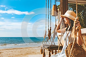 Traveler asian woman travel and relax on swing in beach cafe at Koh chang summer Thailand