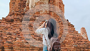 Traveler Asian woman using camera for take a picture while spending holiday trip at Ayutthaya, Thailand, Japanese female tourist