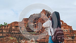 Traveler Asian woman using camera for take a picture while spending holiday trip at Ayutthaya, Thailand, Japanese female tourist