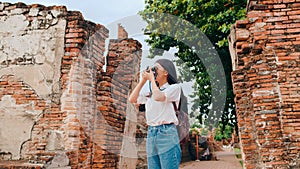 Traveler Asian woman using camera for take a picture while spending holiday trip at Ayutthaya, Thailand, Japanese female tourist