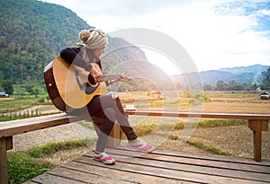 Traveler asian women playing acoustic guitar