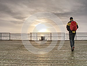 Traveler with back pack at ferry port, pier in touristic resort