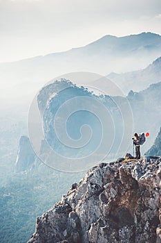 Traveler backpacker on mountains cliff