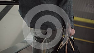 Traveler with bag on escalator going down