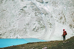 Traveler at blue lake mountains with backpack hiking