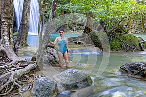 Traveler in blue swimsuit beautiful at  Erawan Waterfall and natural