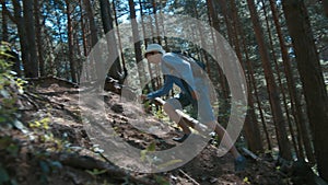 traveler boy walks through the forest goes uphill, cinematic shot