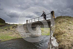 Traveler on a bridge near Gluggafoss waterfall