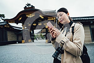 Traveler with camera stand near flatland castle