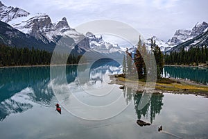 Traveler canoeing in Canadian rockies reflection on Maligne lake at Spirit island in Jasper national park