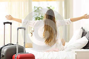 Traveler celebrating vacations in an hotel room
