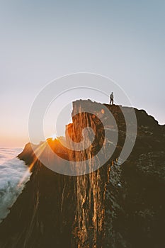 Traveler on cliff hiking alone sunset mountain