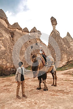 Traveler couple with camel at Goreme fairy chimneys , Cappadocia. Nevsehir Province. Turkey