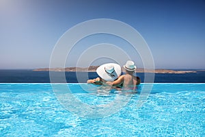 Traveler couple in a infinity pool enjoying the Mediterranean sea