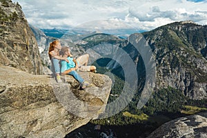 Traveler couple man and woman in Yosemite National Park, scenic view at Valley and Mountains from Upper Yosemite Falls, USA